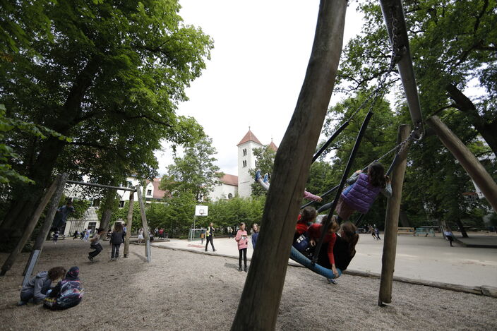 Pausenhof Schaukeln Blick auf Schulgebäude