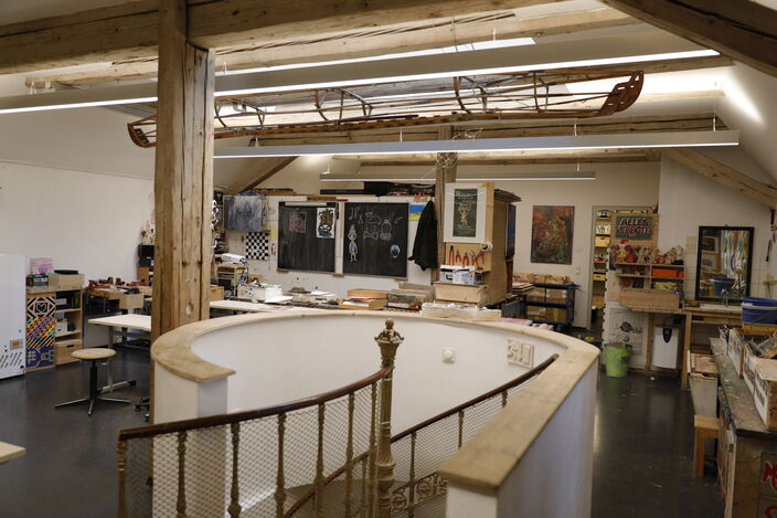 Kunstraum mit Wendeltreppe und Kunstwerken an den Wänden