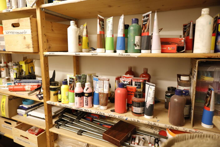 Kunstmaterialregal mit Acrylfarben, Wasserkasten, Kleber